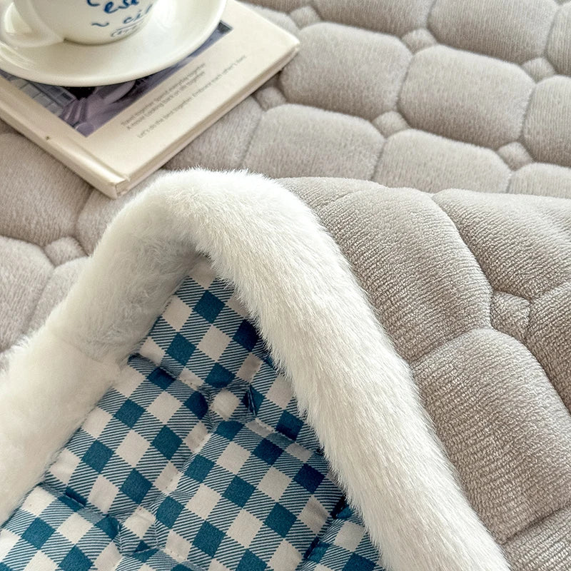 Close-up of gray quilted fleece fabric with white edging and checked backing.