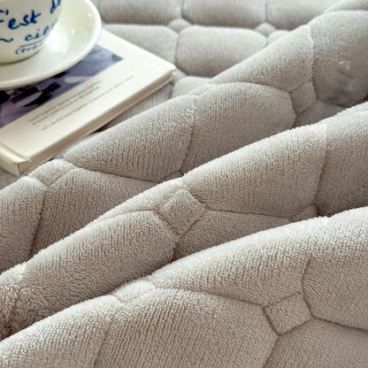 Close-up of the raised quilted pattern on gray fleece bedding.