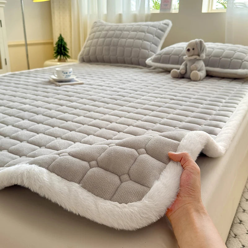 Lifted edge of gray fleece bedding showing a white plush border.