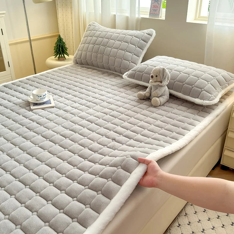 Gray quilted fleece bedding with matching pillowcases and a lifted white-edged corner.