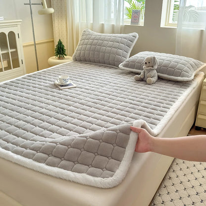 Gray quilted fleece sheet with a lifted corner and matching pillowcases.