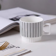 Nordic-style ceramic mug (1 unit), with various graphic prints. Stackable.