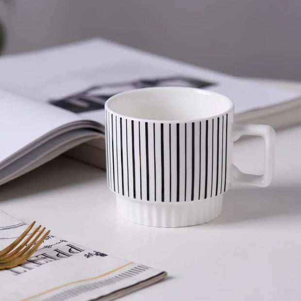Nordic-style ceramic mug (1 unit), with various graphic prints. Stackable.