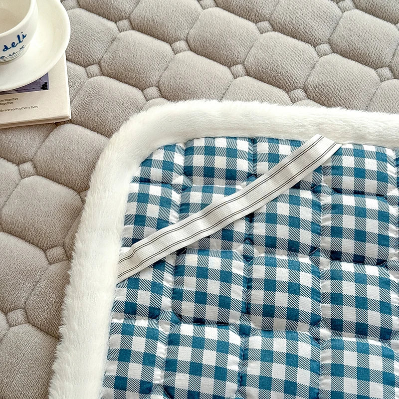 Detail of checked backing and an elastic strap beneath gray fleece bedding.