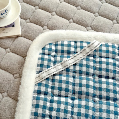 Detail of checked backing and an elastic strap beneath gray fleece bedding.